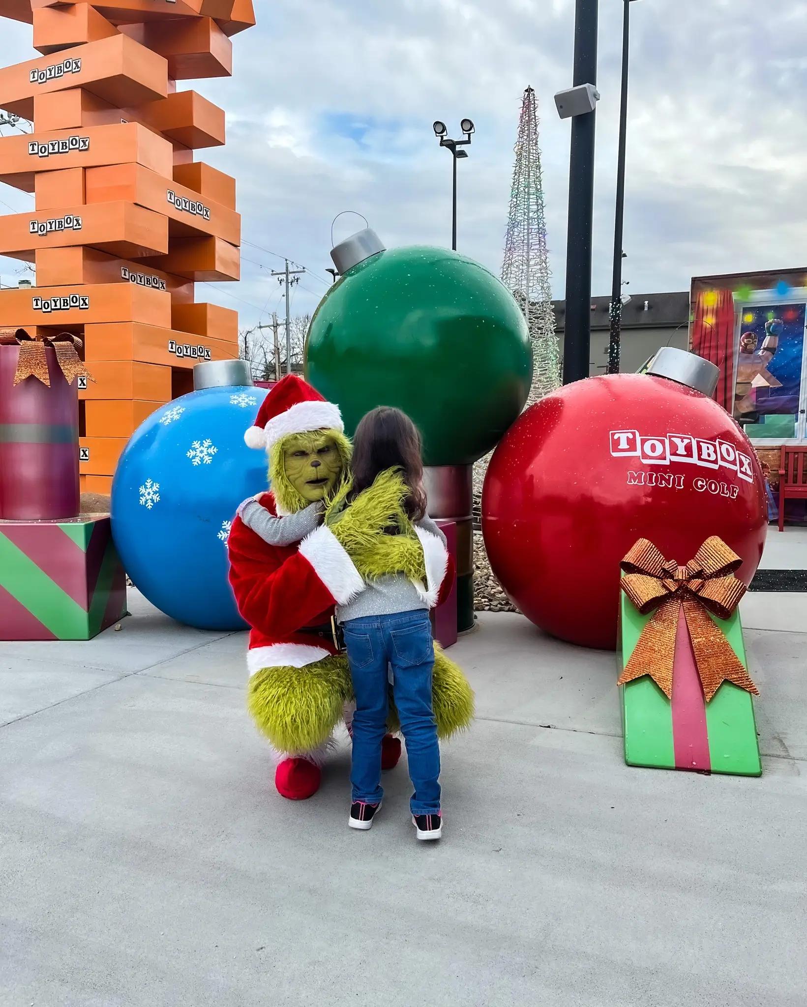 Grinch hugging a child at Christmas