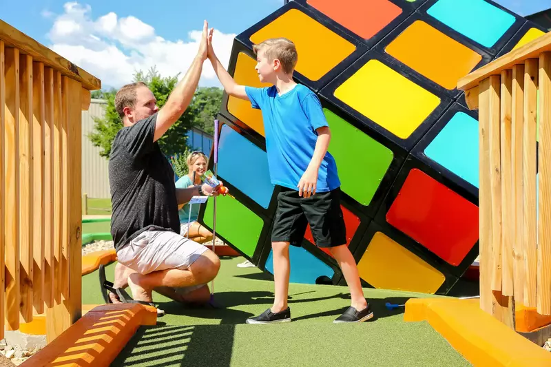 parent and child at mini golf course