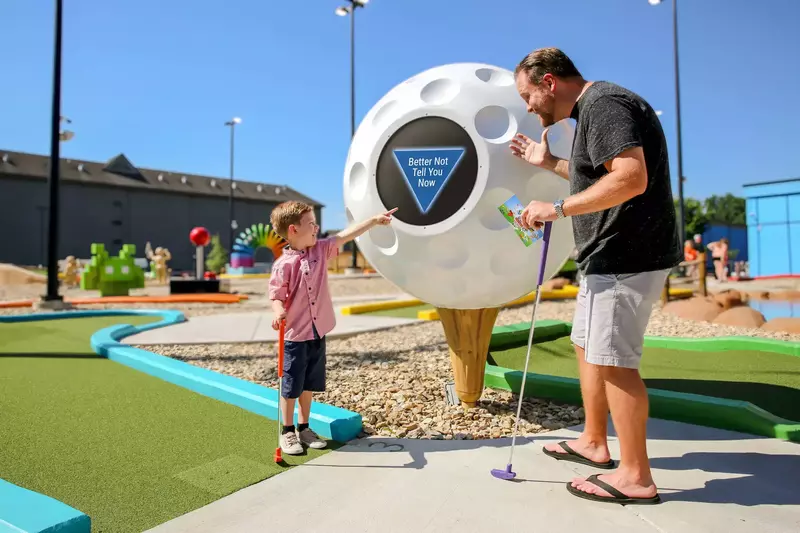 parent and child at mini golf course